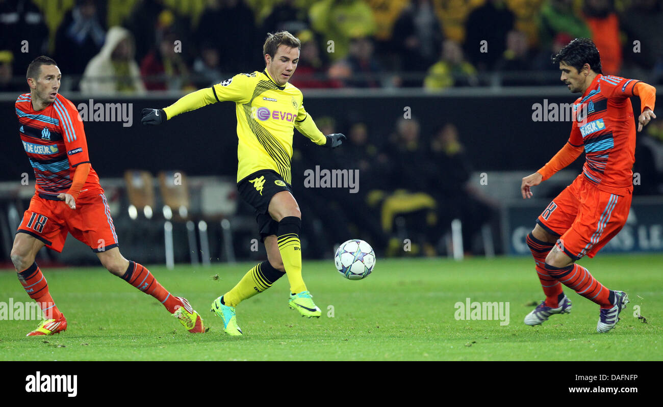 Dortmund's Mario Goetze (C) and Marseille's Morgan Amalfitano (L) and Lucho González (R) vie for the ball during the Champions League group F soccer match between Borussia Dortmund and Olympique Marseille at the BVB Arena in Dortmund, Germany 06 December 2011. Photo: Friso Gentsch dpa/lnw  +++(c) dpa - Bildfunk+++ Stock Photo