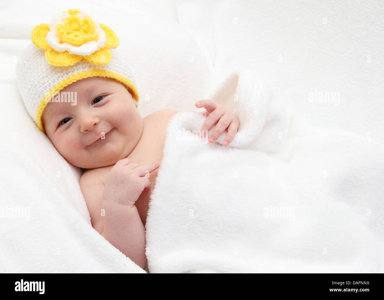 Baby with a knitted white hat baby on back Stock Photo