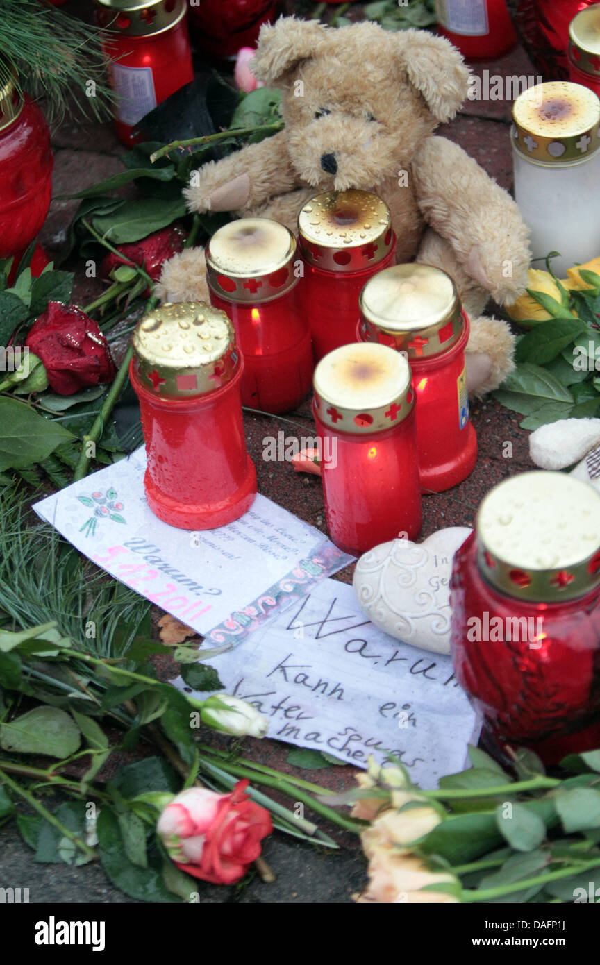 Flowers and candles are lain on the sidewalk in Stolzenau, Germany, 07 December 2011. A man shot his 13 year old daughter there in the middle of the street on Monday afternoon, 05 December 2011, probably because of a family dispute.  He fled afterwards. A police spokesmas said, the 35 year old has still not been caught. Photo: ALEXANDER KOERNER Stock Photo