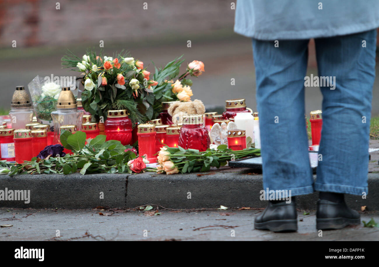Flowers and candles are lain on the sidewalk in Stolzenau, Germany, 07 December 2011. A man shot his 13 year old daughter there in the middle of the street on Monday afternoon, 05 December 2011, probably because of a family dispute.  He fled afterwards. A police spokesmas said, the 35 year old has still not been caught. Photo: ALEXANDER KOERNER Stock Photo