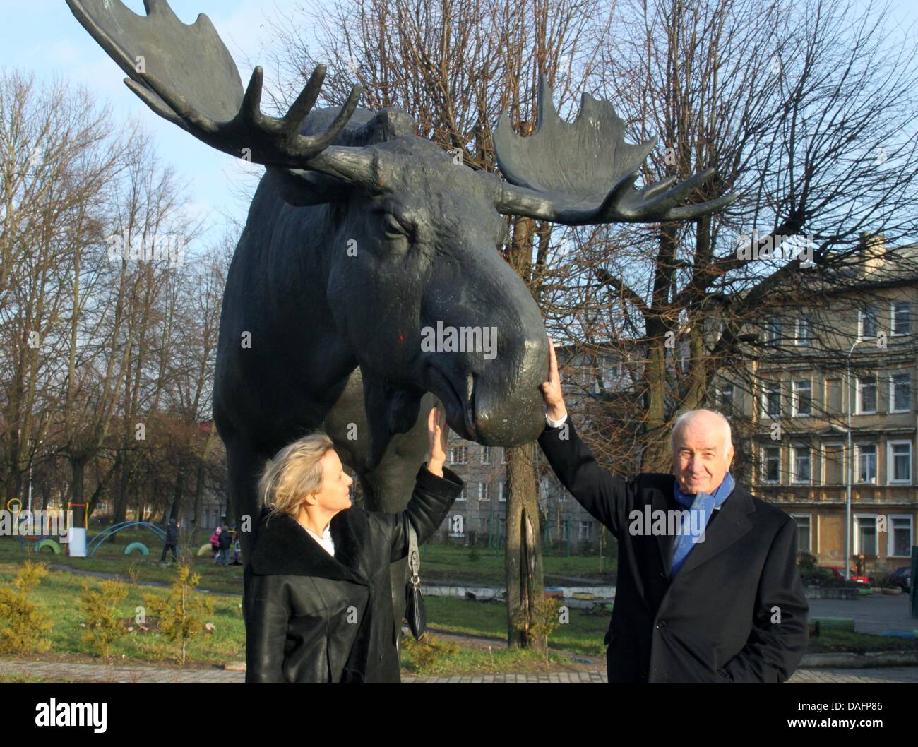 German actor Armin Mueller-Stahl and his wife Gabriele stand next to a statue of an elk, which is the landmark of his city of birth 'Tilsit', named Sovetsk today, Russia, 07 December 2011. The artist and actor visited the city for the first time in 73 years to receive an award as honorary citizen of the town on 07 December 2011. Photo: Thoralf Plath Stock Photo