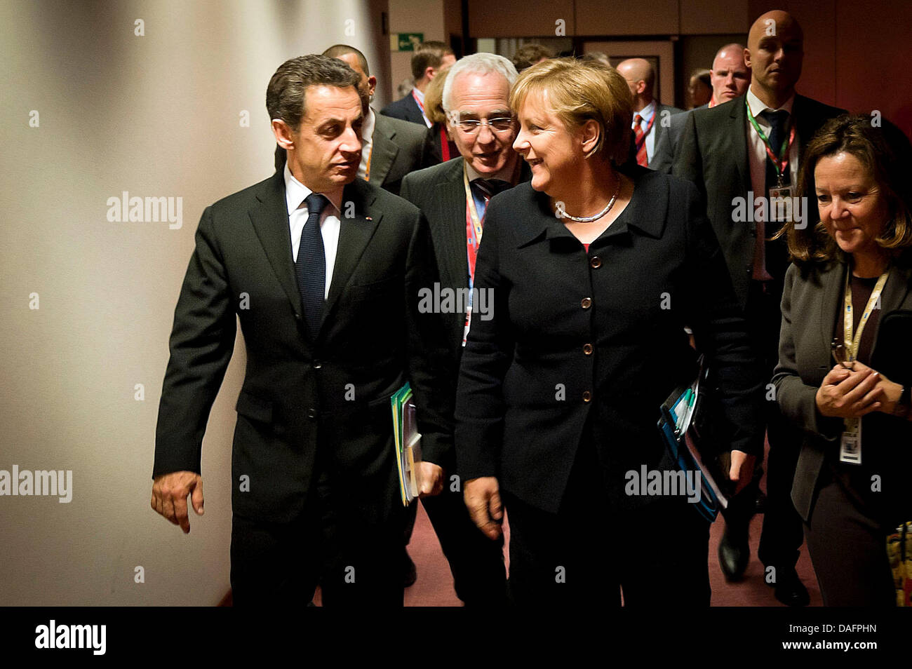 Bundeskanzlerin Angela Merkel (CDU, M) und Frankreichs Staatspräsident Nicolas Sarkozy (l) unterhalten sich in Brüssel, Belgien, auf dem Weg zum Arbeitsabendessen der Staats- und Regierungschefs am Donnerstag (08.12.2011) beim EU-Gipfel. Rechts und 2.v.l. ihre Dolmetscher. Merkel hatte vorher für eine Veränderung der EU-Verträge und für eine Stärkung der europäischen Institutionen  Stock Photo