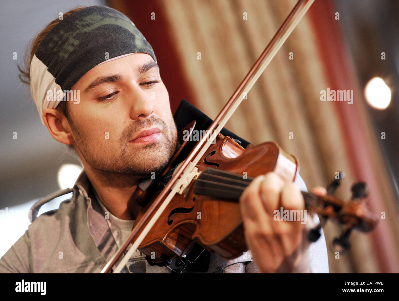Violinist David Garrett plays during a press conference in Hamburg, Germany, 09 December 2011. Gerrett will come to 02 World in Hamburg with band and orchestra for his 'Rock Anthems' tour on 12 April 2012. Photo: ANGELIKA WARMUTH Stock Photo