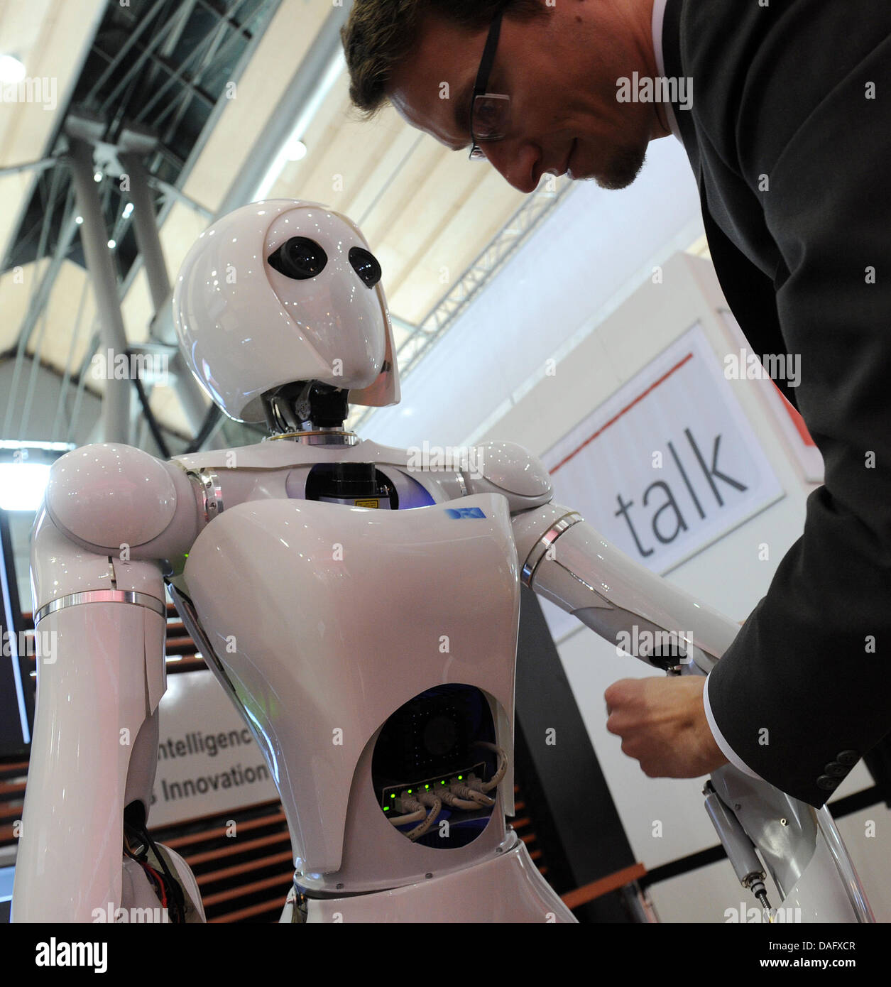 Andreas Vogt, reasearch associate of the DFKI looka fter robot AILA at the international computer fair CeBIT 2011 in Hanover, Germany, 04 March 2011. The robot can transport many differently shaped objects. More than 4200 companies from 70 countires present their newest products from the 1-5 March 2011 in Hanover. Photo: Caroline Seidel Stock Photo