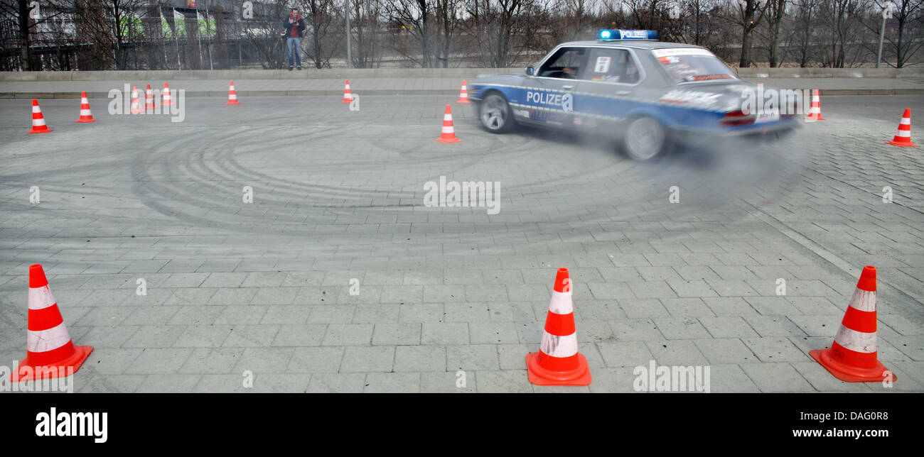 Professional stunt driver Alexander Graeff drifts in an old police car during a publicity show for the car shows AMITEC, AMICOM and AMISTYLE in Leipzig, Germany, 9 March 2011. The racing series Gymkhana Drift Cup kicks off from 9 to 13 April as supporting programme for the car shows. So far, 32 European teams have registerd to participate. The trade shows AMITEC, AMICOM and AMISTYL Stock Photo