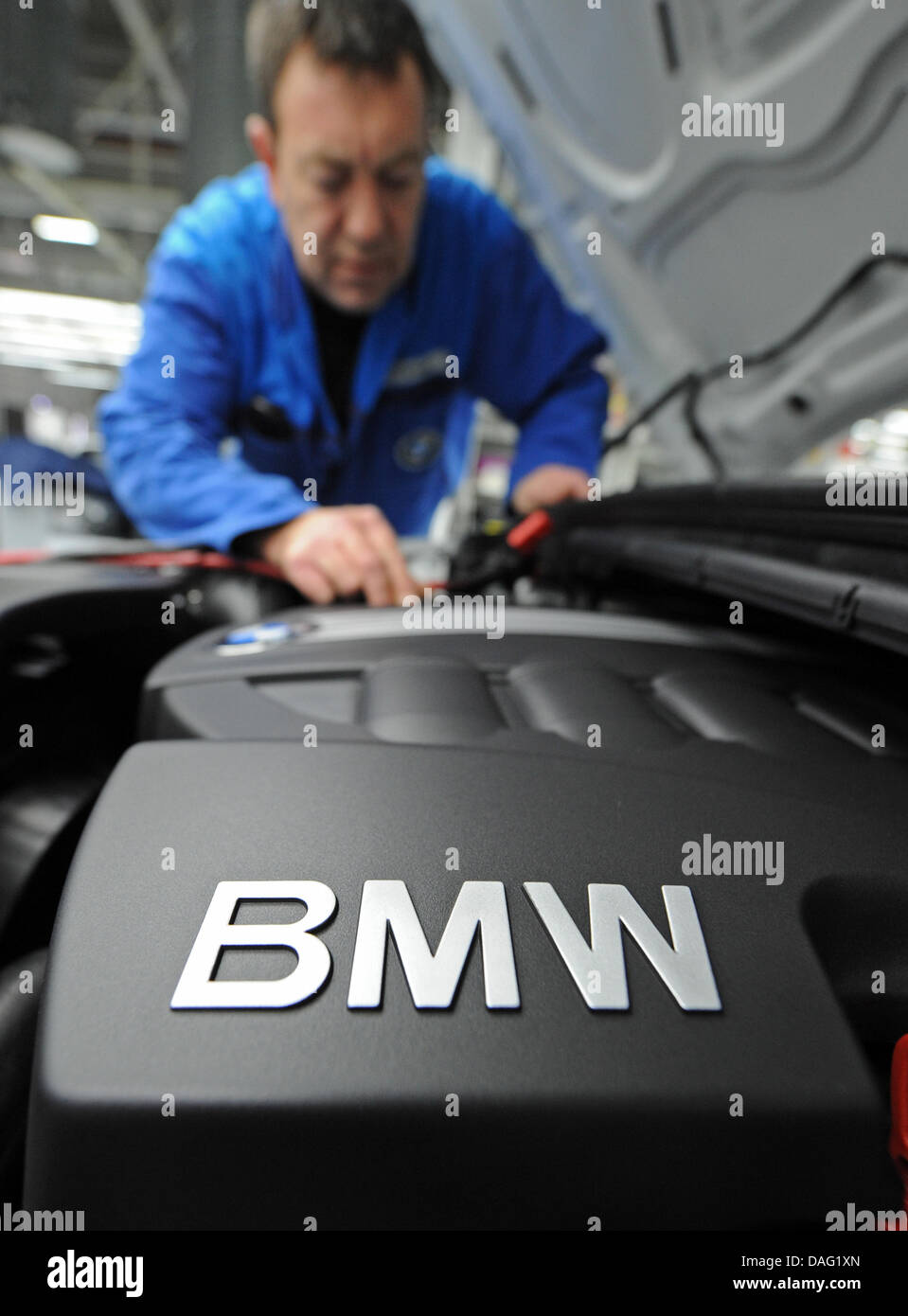 (dpa file) A file pictured dated 08 November 2010 shows a man working on a car engine at the BMW factory in Regensburg, Germany. After two meager years BMW is making record net profits. In 2010 the Munich-based car manufacturer made 3.234 milliard Euro, according to statement on thursday. Photo: Armin Weigel Stock Photo