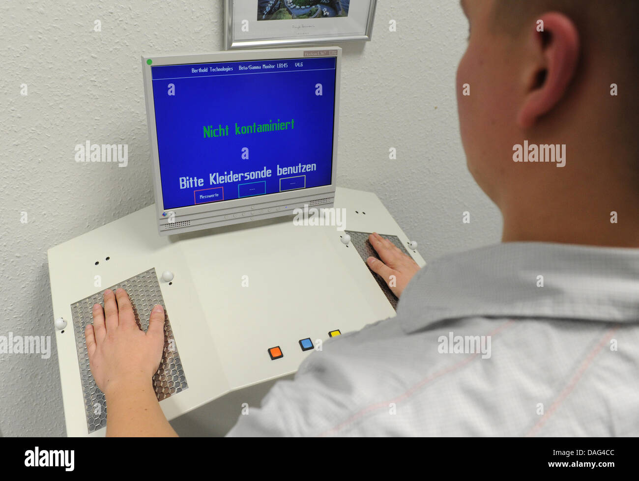 A young man demonstrates the usage of a 'HandFootClothingMonitor' at