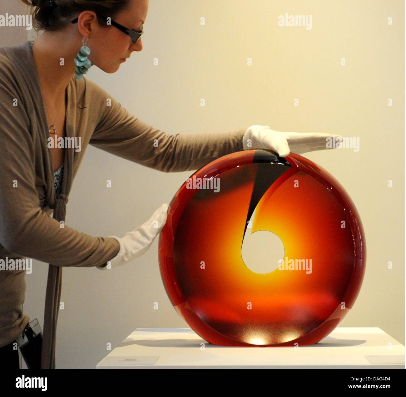 The picture shows a female employee of the fair arranging the exhibit 'Callista' by the Czeck  artist Petr Hora at the Craftmanship Fair (IHM) in Munich, Germany on 16 March 2011. The Craftmanship Fair (IHM) will be held until 22 March 2011 and focuses especially on energy, working, living, building, houses and gardens. Photo: Tobias Hase Stock Photo