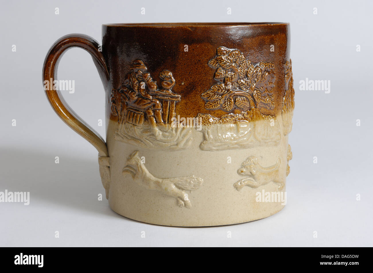 An English salt glaze stoneware mug with applied (sprigged) hunting and toping (drinking) scenes. Probably Mid 19th C. Stock Photo