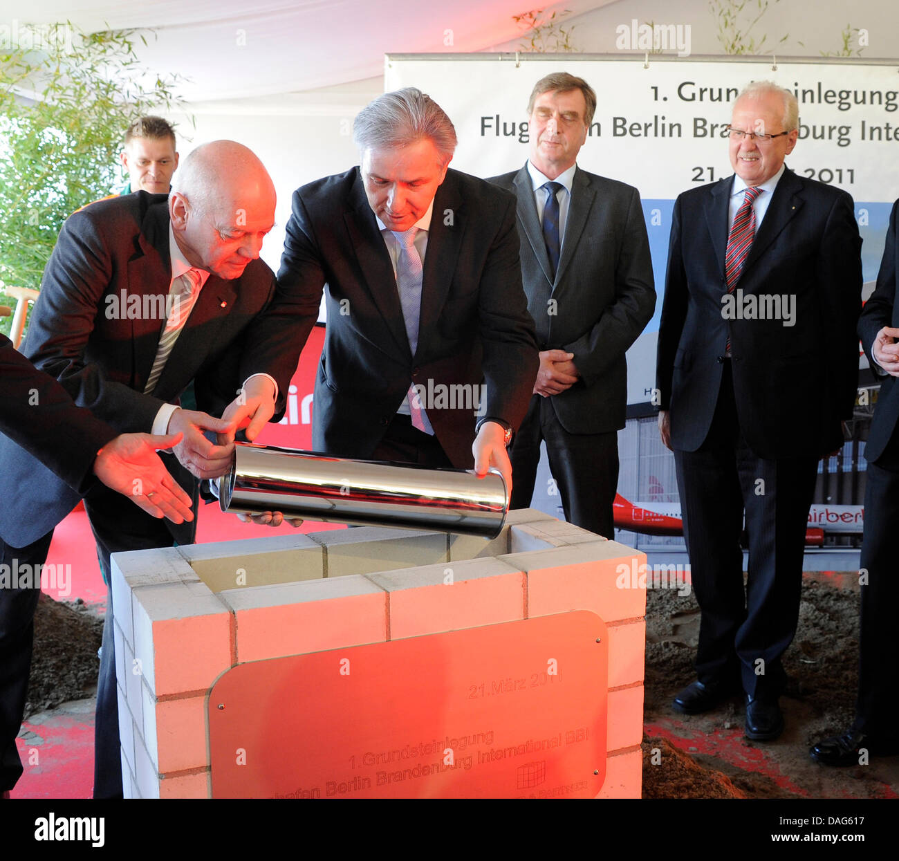 Air Berlin CEO Joachim Hunold (L) and Berlin Mayor Klaus Wowereit (2-L) lay down the foundational stone for a new Air Berlin hangar at Berlin-Brandenburg International Airport (BBI), which is still under construction in Schoenefeld, Germany, 21 March 2011. Brandenburg's Economy Minister Ralf Christoffers (2-R) and BBI managing director Manfred A. Koertgen (R) watch the ceremonial a Stock Photo