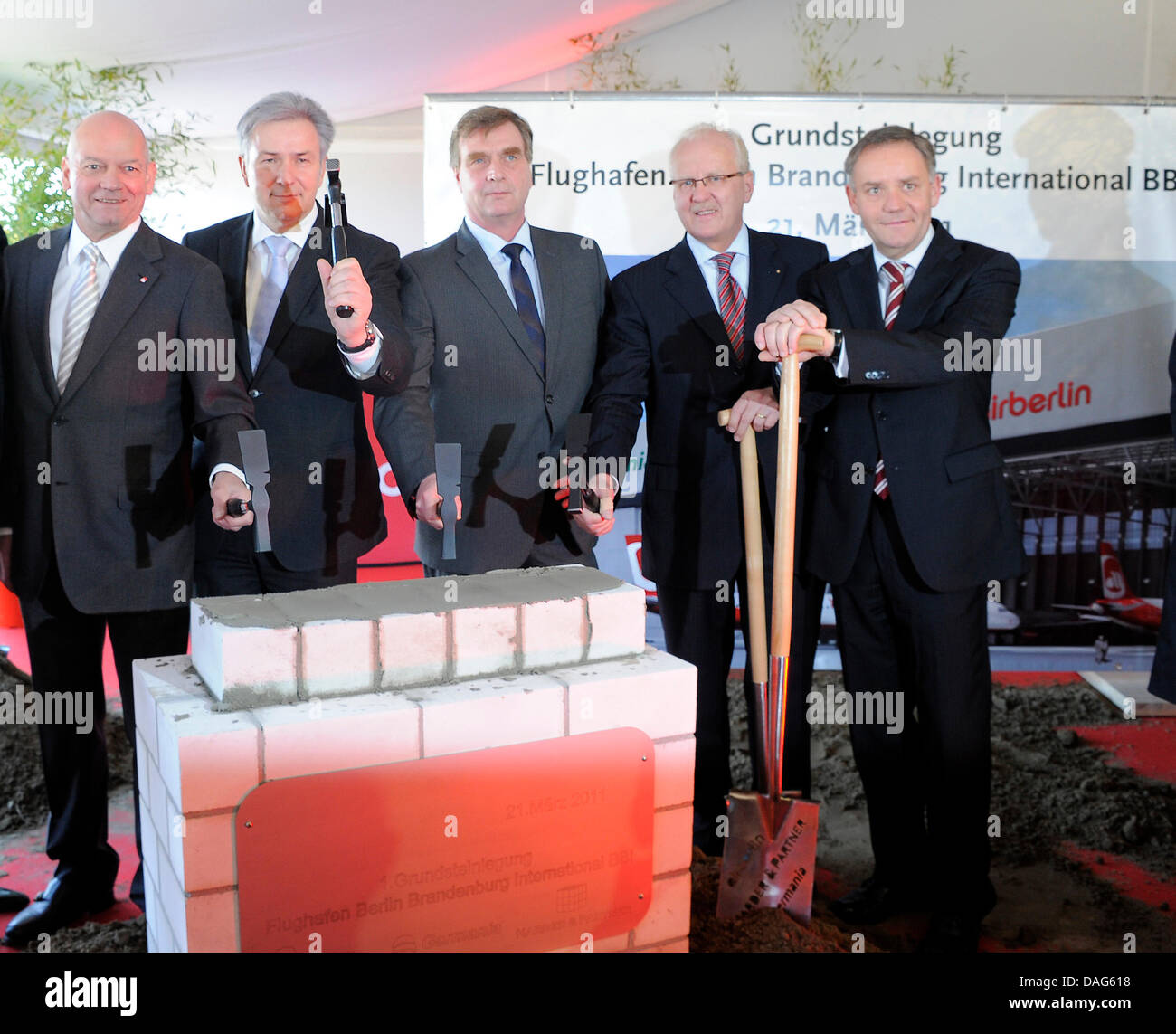 (L to R:) Air Berlin CEO Joachim Hunold, Berlin Mayor Klaus Wowereit, Brandenburg's Economy Minister Ralf Christoffers and BBI managing director Manfred A. Koertgen lay down the foundational stone for a new Air Berlin hangar at Berlin-Brandenburg International Airport (BBI), which is still under construction in Schoenefeld, Germany, 21 March 2011. The new hangar can accomodate six  Stock Photo