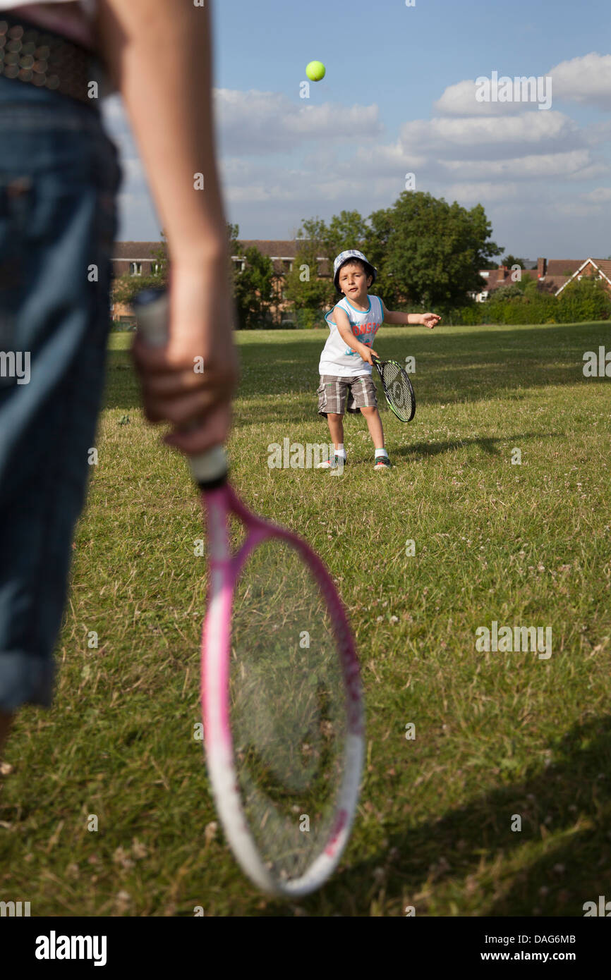 Child plays tennis with parent Stock Photo