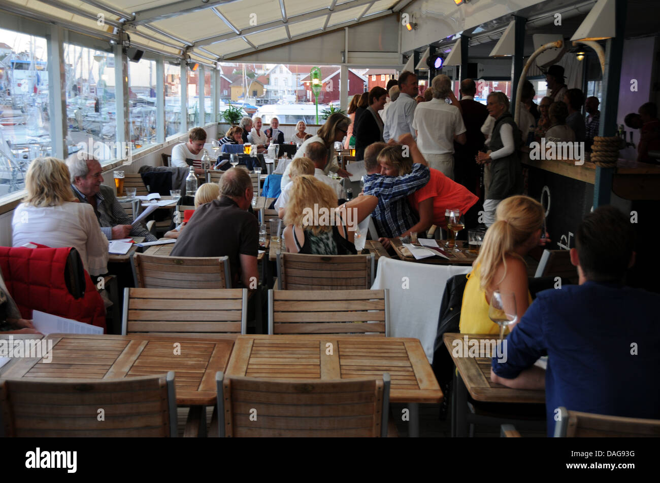 Restaurant filled with people dancing to local music on island of Gullholmen on West Coast of Sweden Stock Photo
