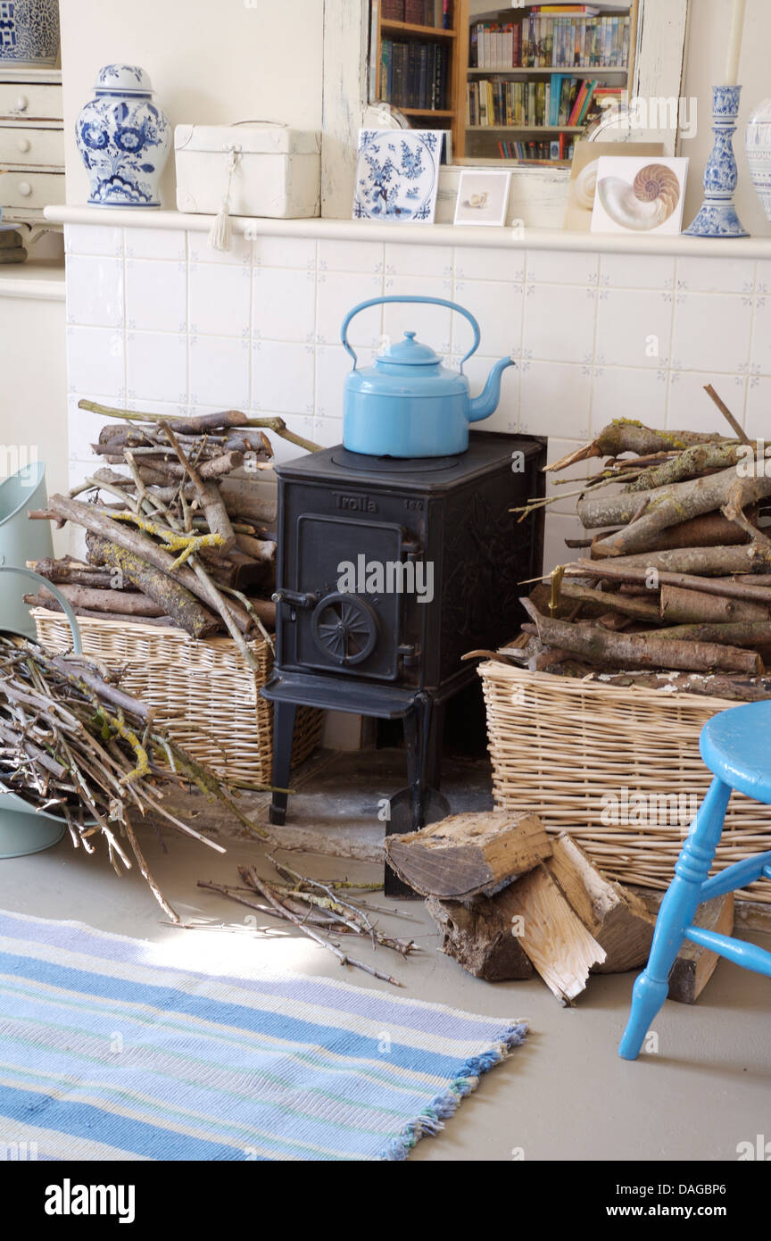 Blue enamel kettle on small black wood burning stove in dining room