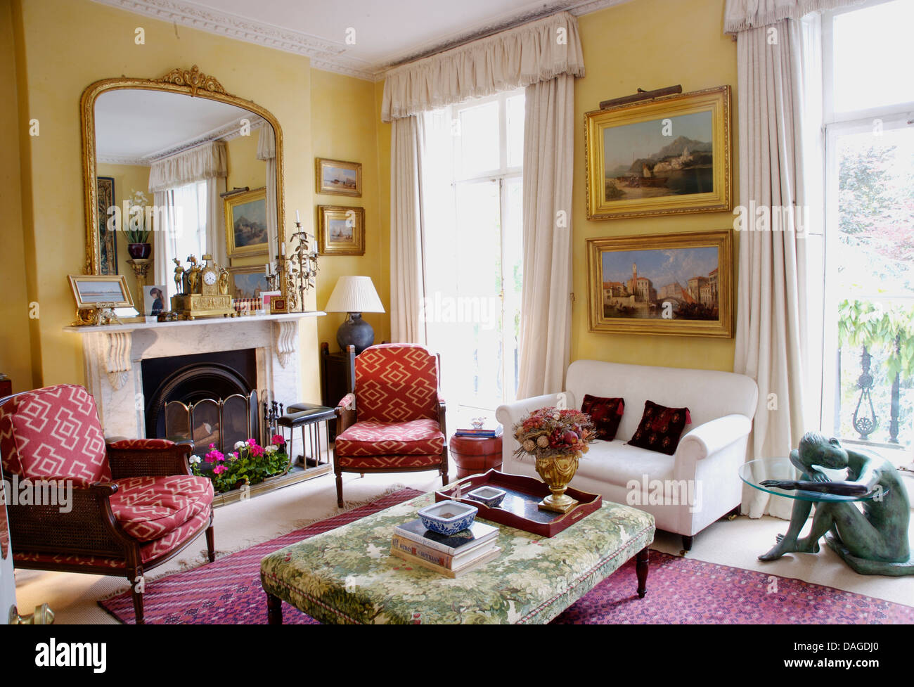 Large gilt antique mirror above fireplace in town house living room ...