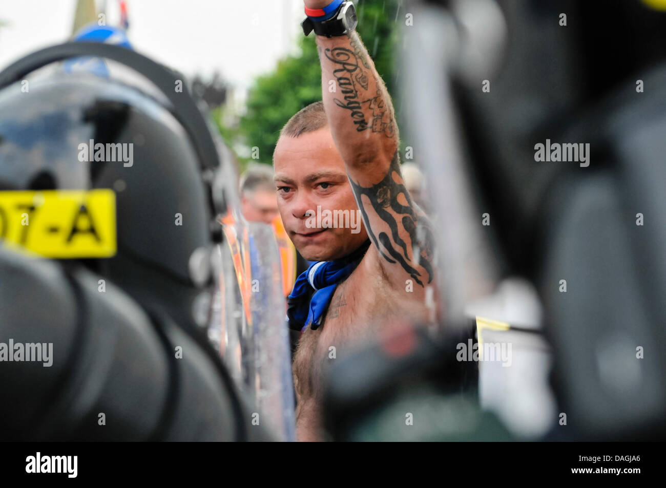 Belfast, Northern Ireland, 12th July 2013 - An angry loyalist confronts PSNI officers dressed in riot gear with helmets and shields in Belfast Credit:  Stephen Barnes/Alamy Live News Stock Photo