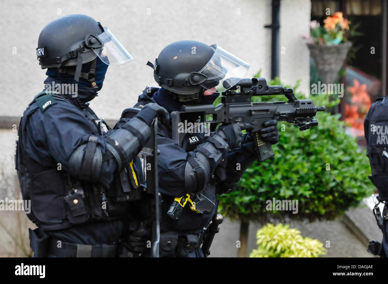 Belfast, Northern Ireland, 12th July 2013 - A PSNI officer from the ARV unit wearing a ballistics helmet aims a Heckler & Koch G36C assault rifle. His colleague holds a ballistic protective shield  Credit:  Stephen Barnes/Alamy Live News Stock Photo