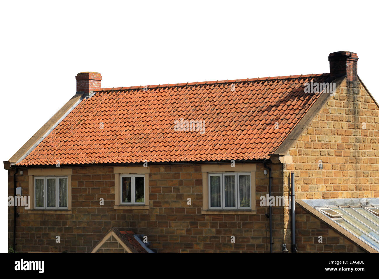 Exterior of brick house with red roof tiles isolated on white background. Stock Photo