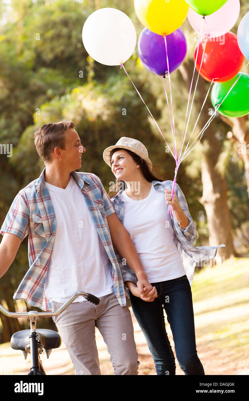 cute teen couple walking at the park holding hands Stock Photo