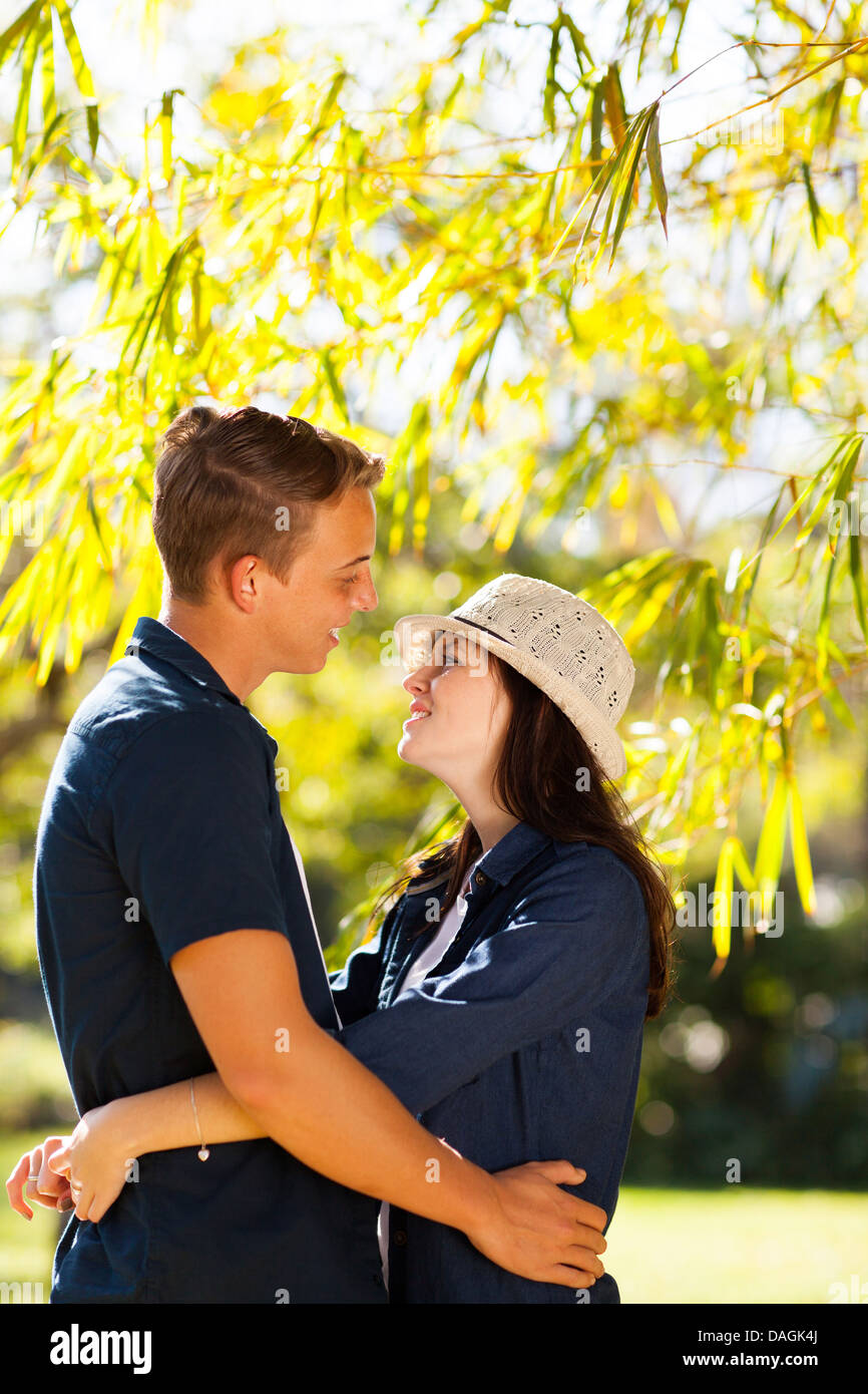 young teenage couple hugging outdoors in forest Stock Photo