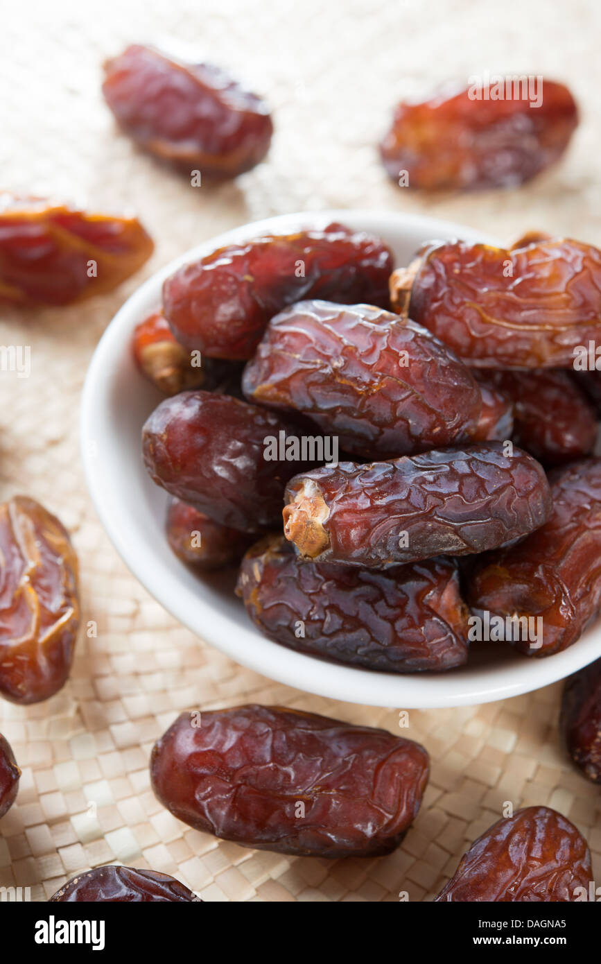 Dried date palm fruits or kurma, ramadan food which eaten in fasting month. Pile of fresh dried date fruits in a plate. Stock Photo
