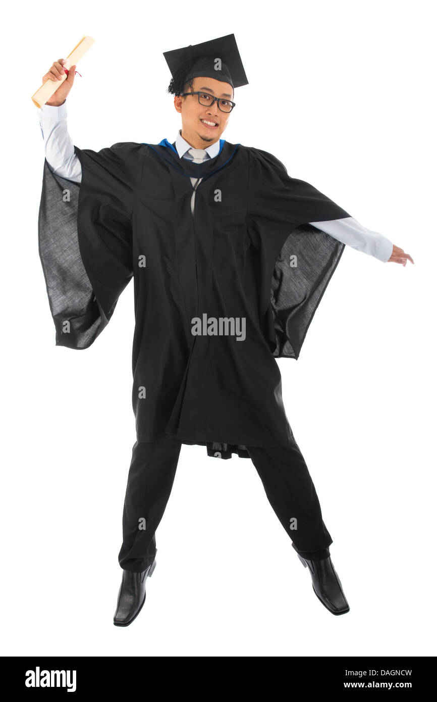 Full body excited Asian male university student in graduation gown jumping isolated on white background Stock Photo