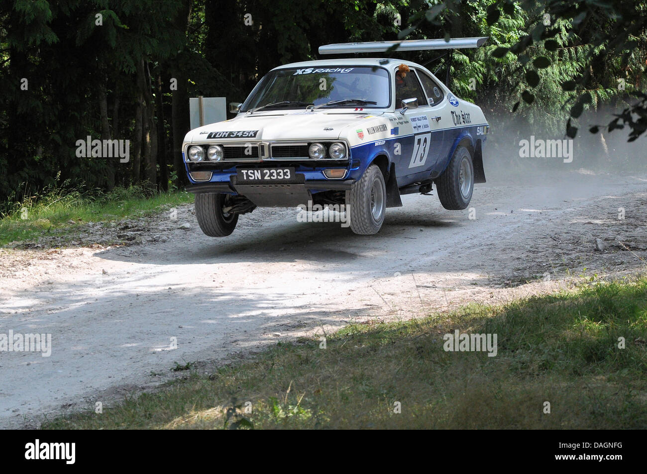 Vauxhall Firenza rally car jumping through the forest stage at the Goodwood Festival of Speed motorsport event, UK. 1972 built car Stock Photo