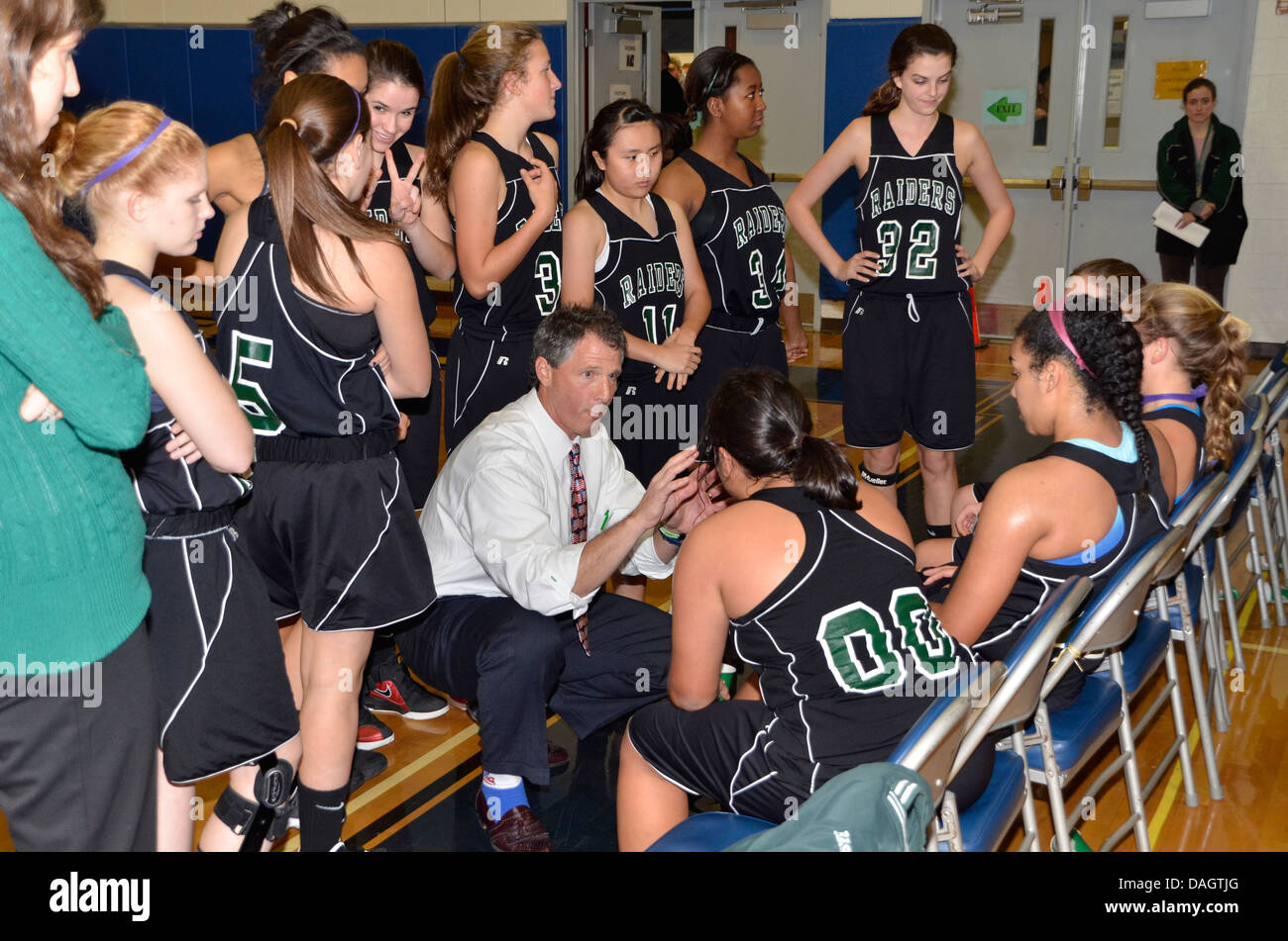 Coach discusses strategy with his team at the high school basketball game Stock Photo