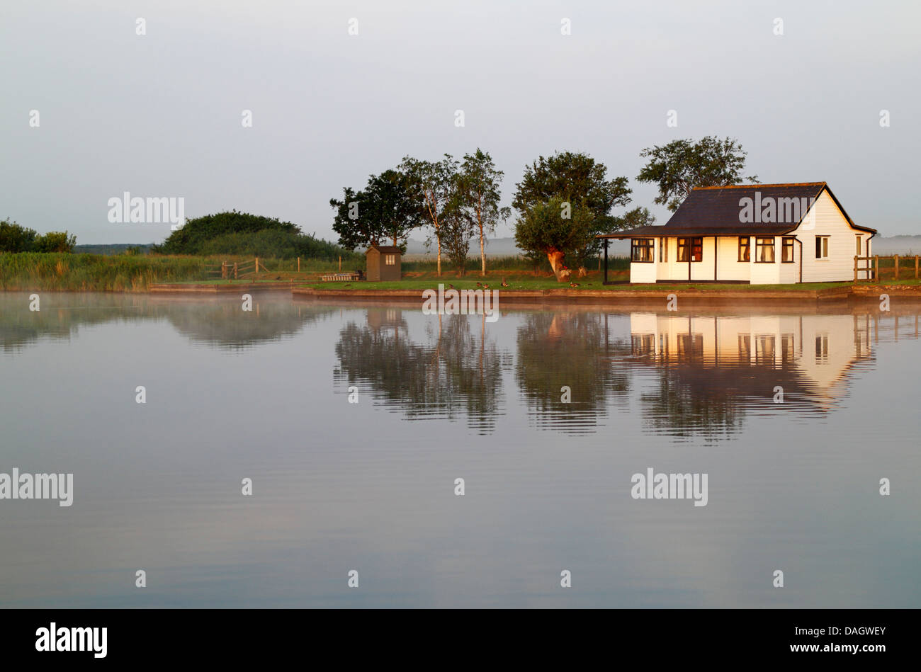 A view of a riverside property with reflections on the Norfolk Broads