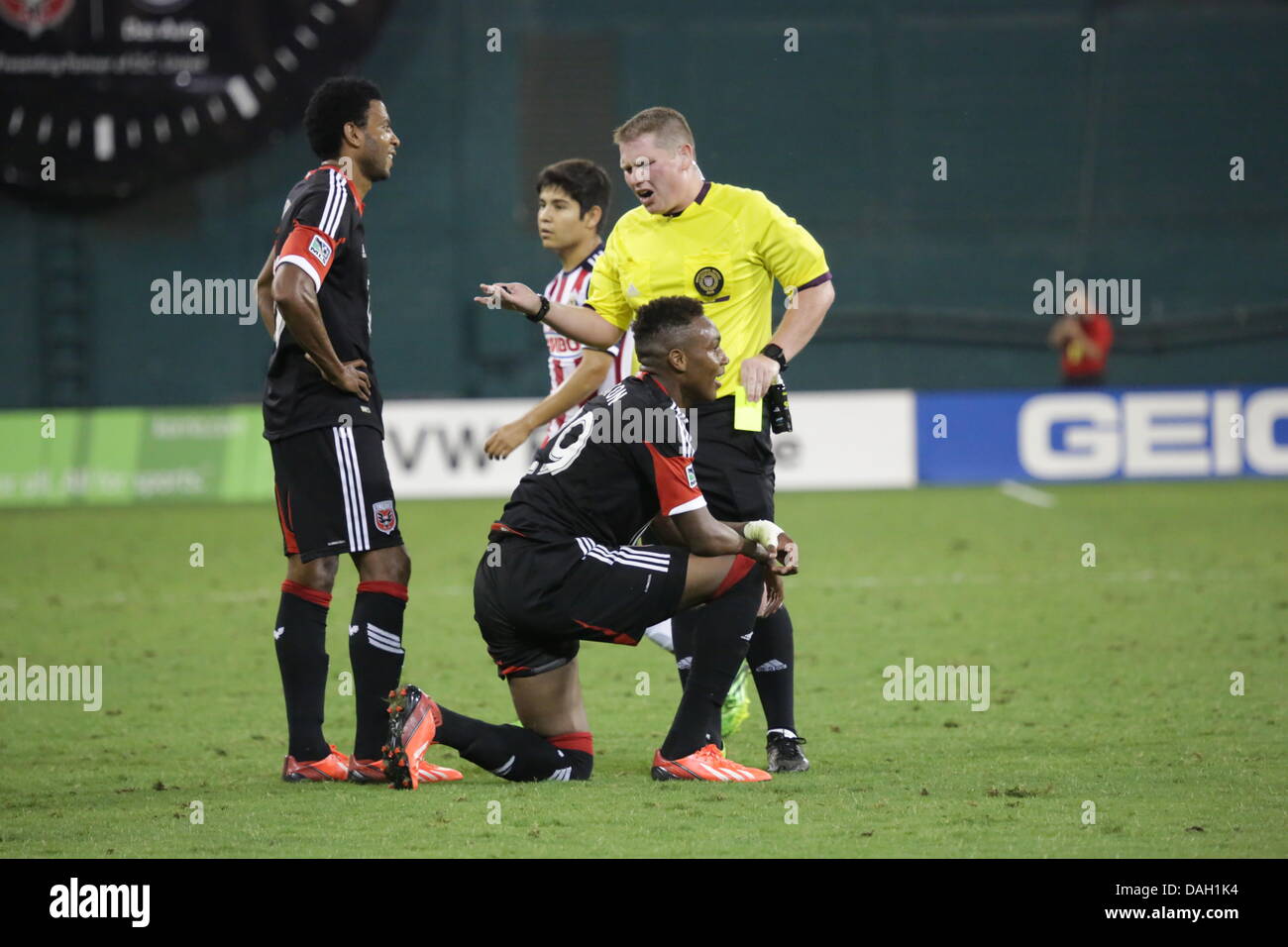 Washington DC, USA. 12th July 2013. Washington DC RFK Stadium Friendly Soccer Match between the D.C. United and the Guadalajara Chivas. Michael Seaton (29) is given a talking to from the ref on the hard tackle. Seaton is given a yellow card. Stock Photo