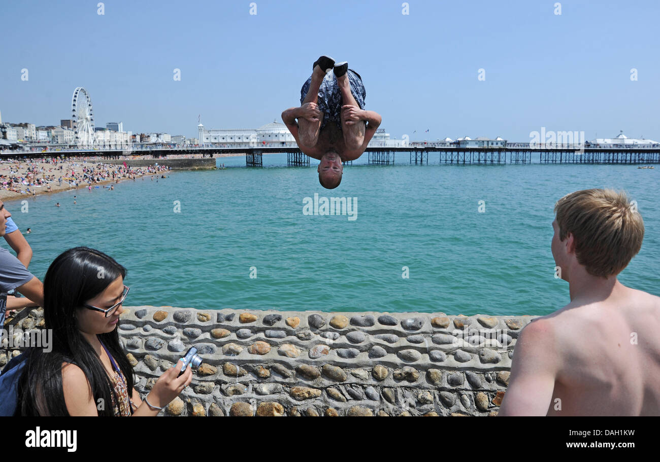 Brighton UK 13 July 2013 - Young men leaping or tombstoning as it is known from a groyne into the sea on Brighton beach today Stock Photo