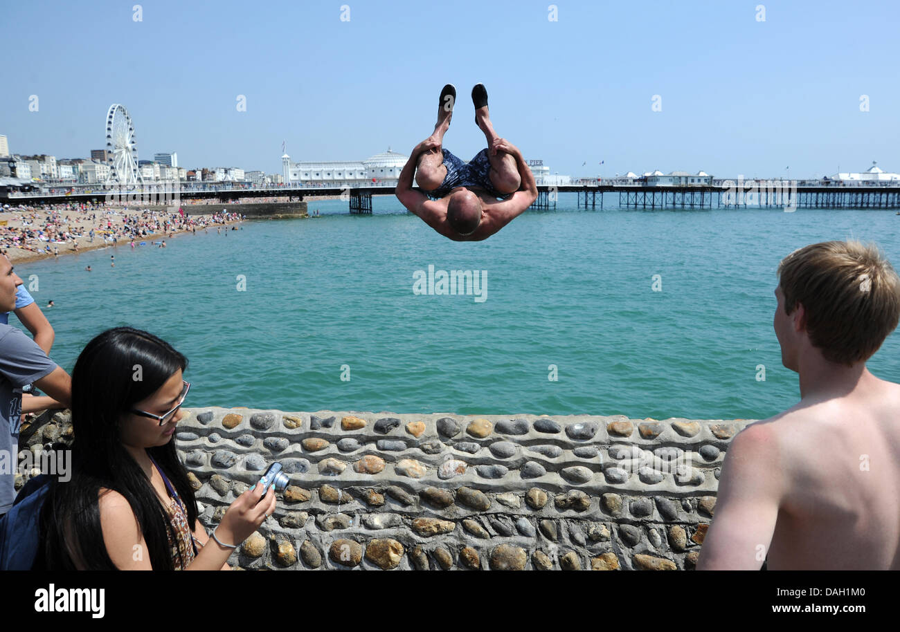 Brighton UK 13 July 2013 - Young men leaping or tombstoning as it is known from a groyne into the sea on Brighton beach today Stock Photo