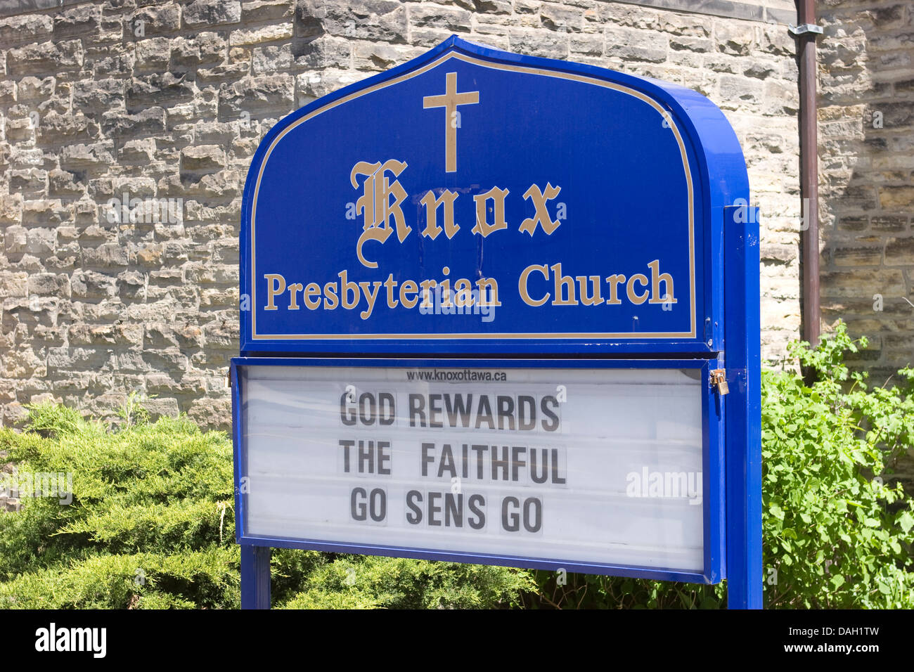 Sign outside the Knox Presbyterian Church, Ottawa: GOD REWARDS THE FAITHFUL GO SENS GO.  Sens are the ice hockey team Senators. Stock Photo