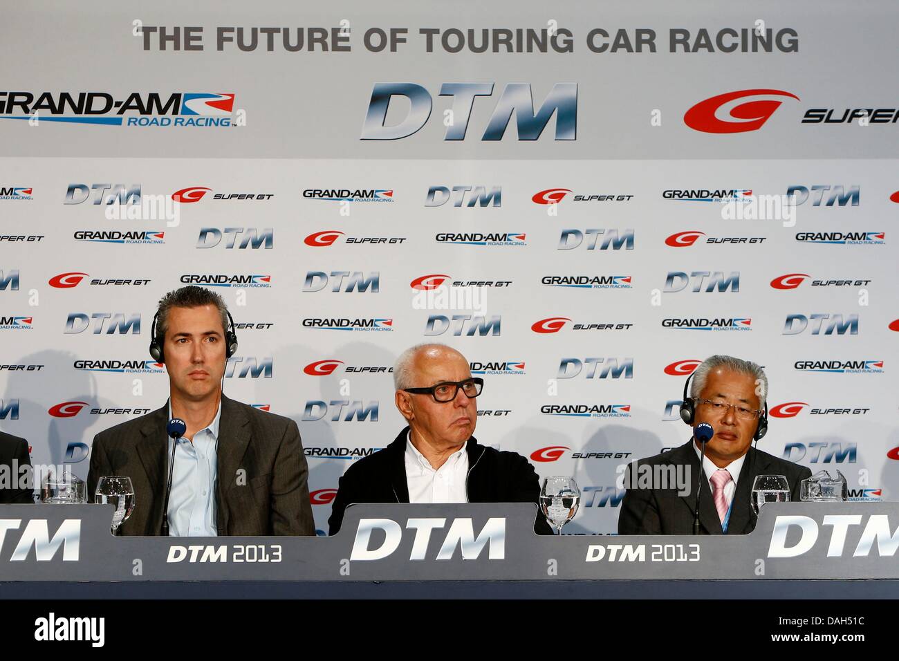 Grand Am president Ed Bennett (L-R), Hans Werner Aufrecht, chairman of DTM right holder and marketer ITR, and Masaaki Bandoh, chairman Super GT promoter GT association, sit at a press conference at the Norisring in Nuremberg, Germany, 13 July 2013. The managers spoke about the planned US version of the race series and about the adaptation of the technical regulations of the DTM in the Japanese Super GT in 2014. Photo: JUERGEN TAP Stock Photo