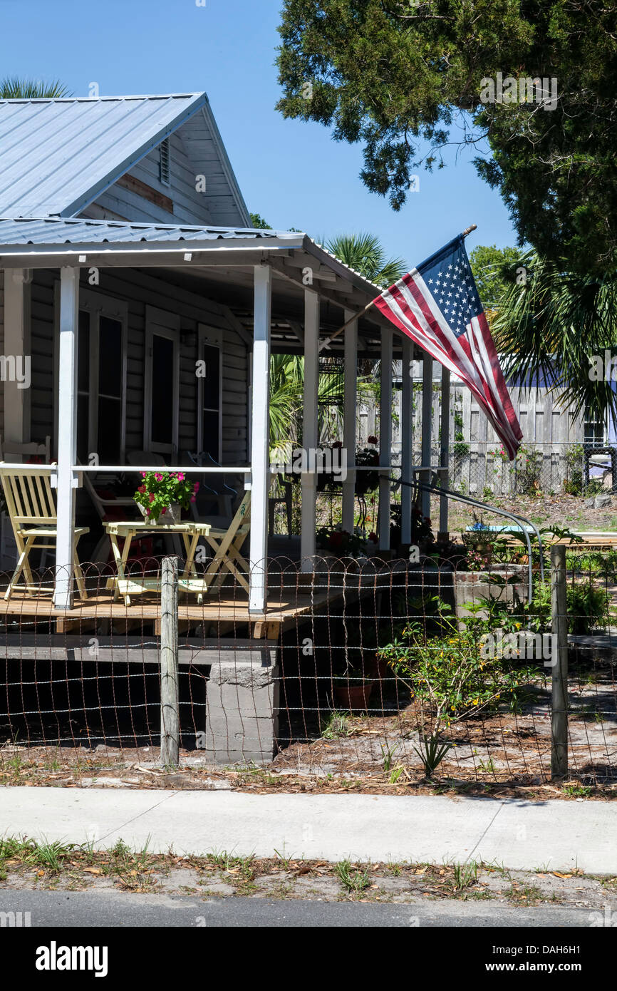 Old Glory American stars and stripes flag waves from wide veranda of a Cedar Key, Florida bungalow. Stock Photo