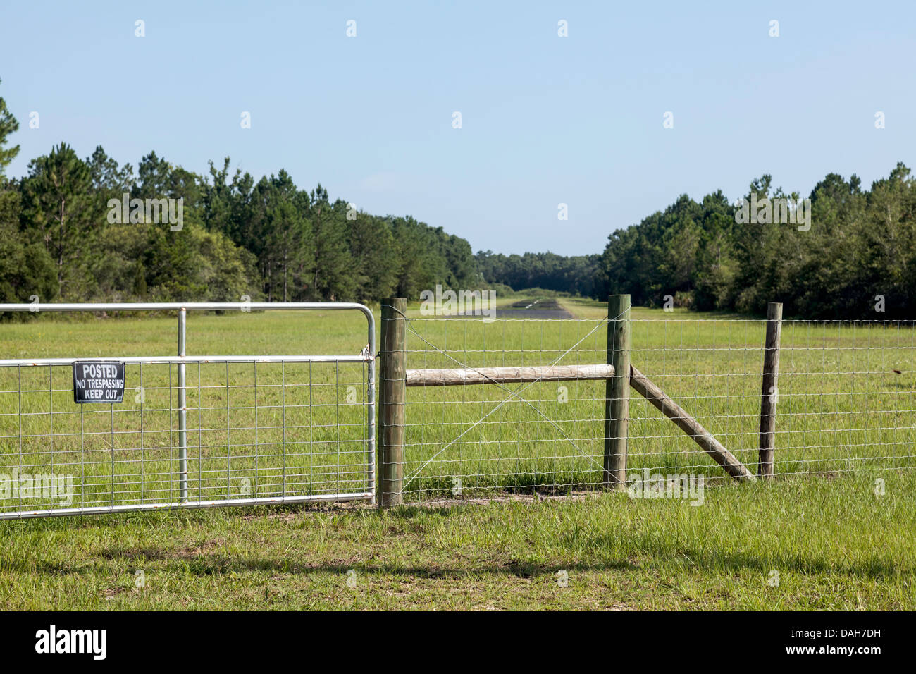 Fenced entry gate protects rural landing strip beyond in Cedar Key, Florida area. Stock Photo