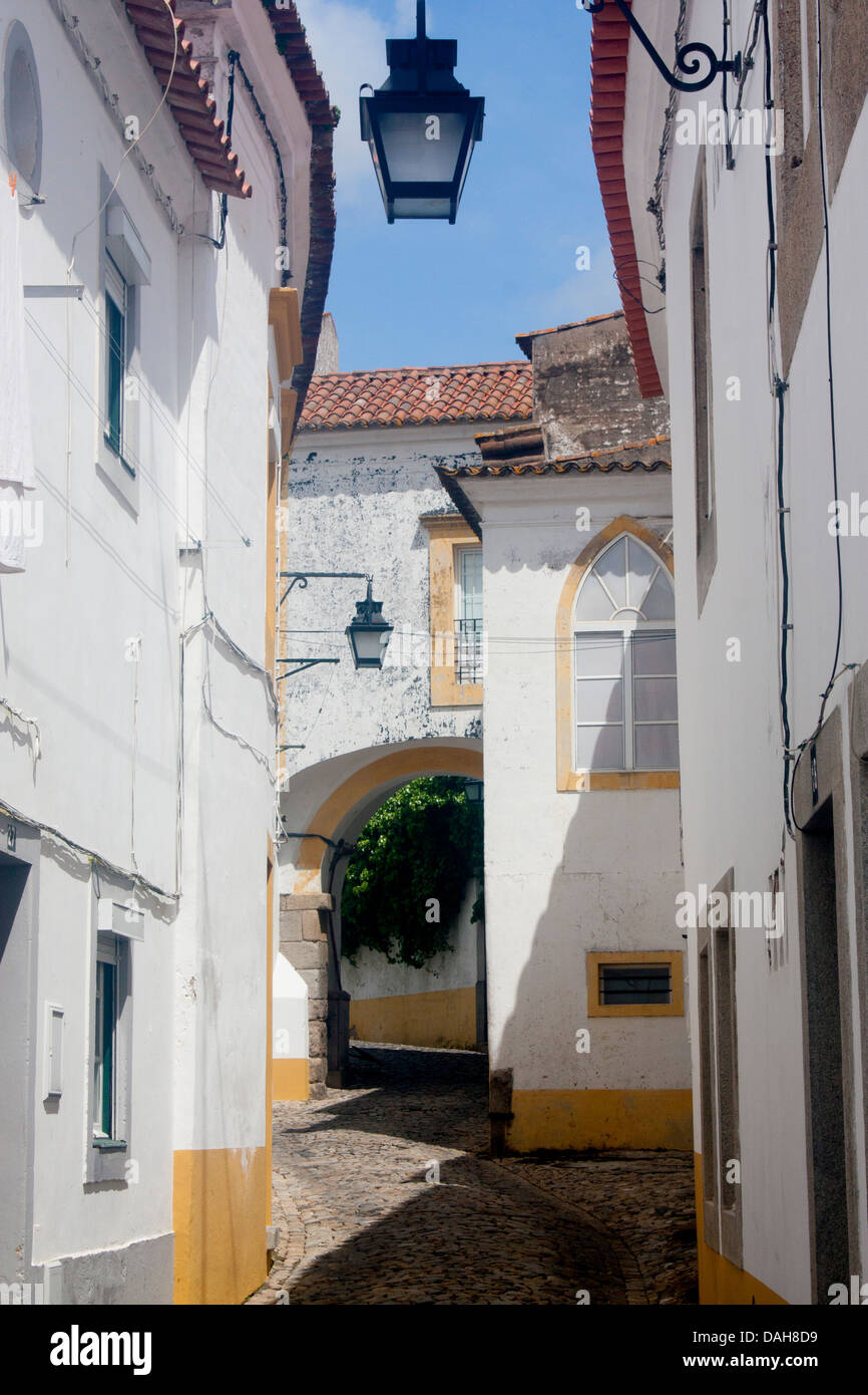 Typical whitewashed street scene cobbled medieval street Rua Freiria de Baixo Evora Alentejo Portugal Stock Photo