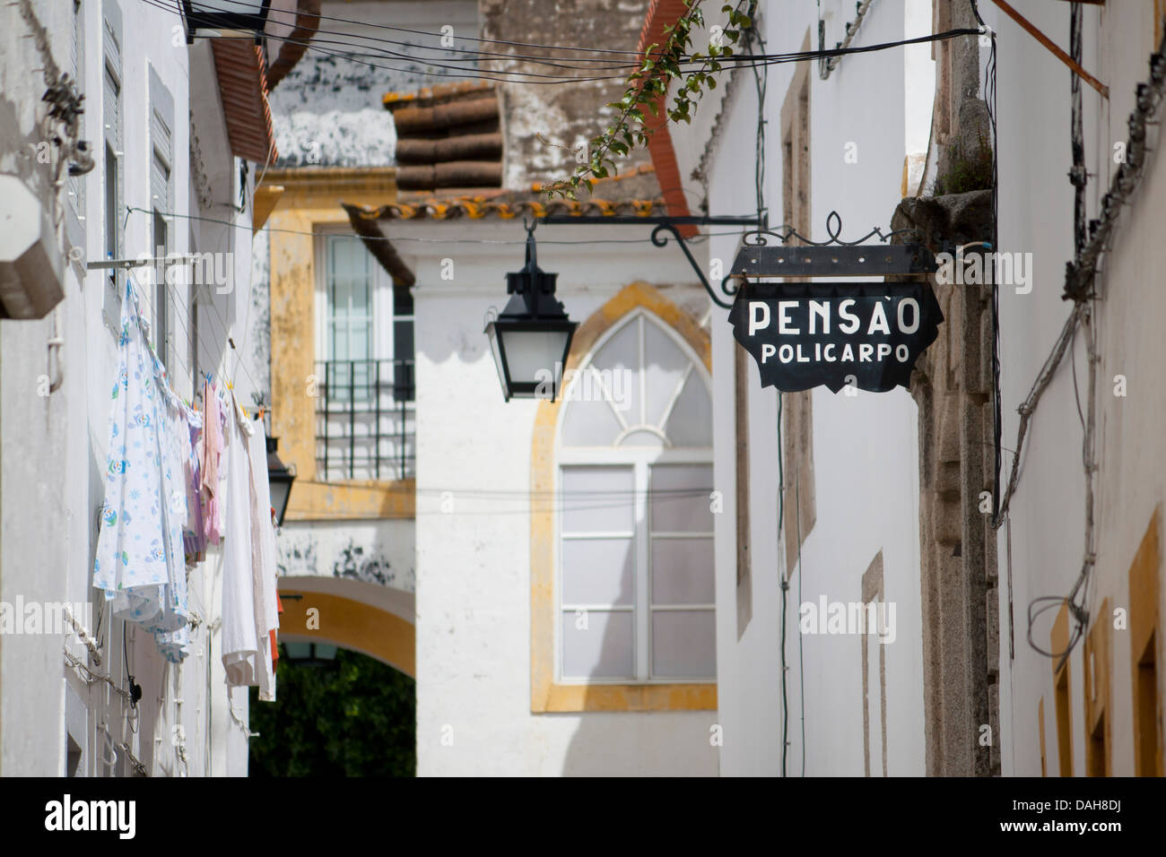Street with typical whitewashed buildings, street lamps, architectural details and pensao or hotel sign Évora Alentejo Portugal Stock Photo