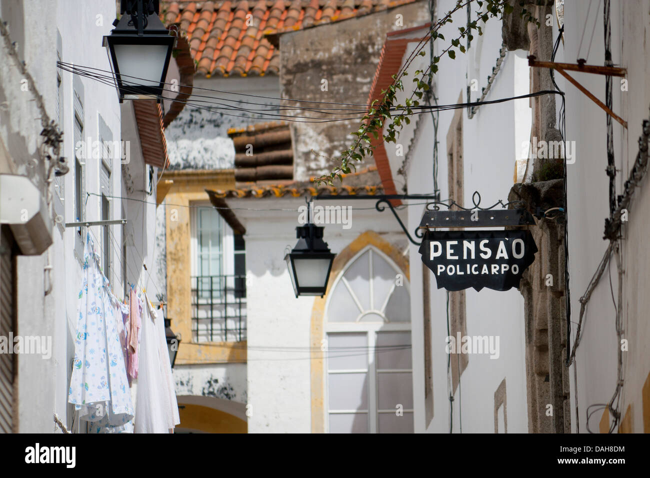 Street with typical whitewashed buildings, street lamps, architectural details and pensao or hotel sign Évora Alentejo Portugal Stock Photo