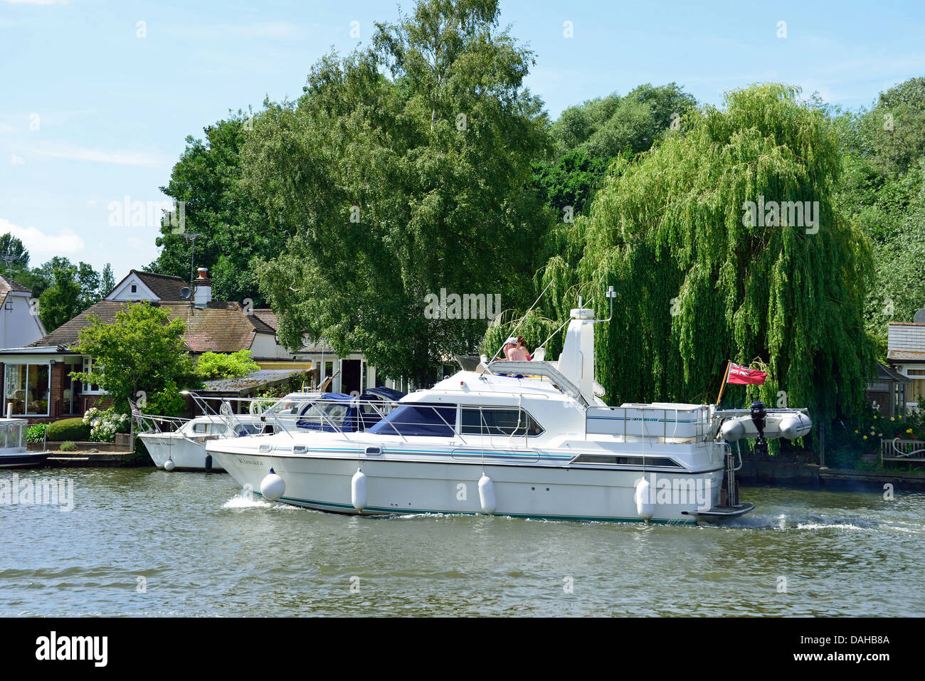 Leisure boat passing riverside houses on River Thames, WaltononThames