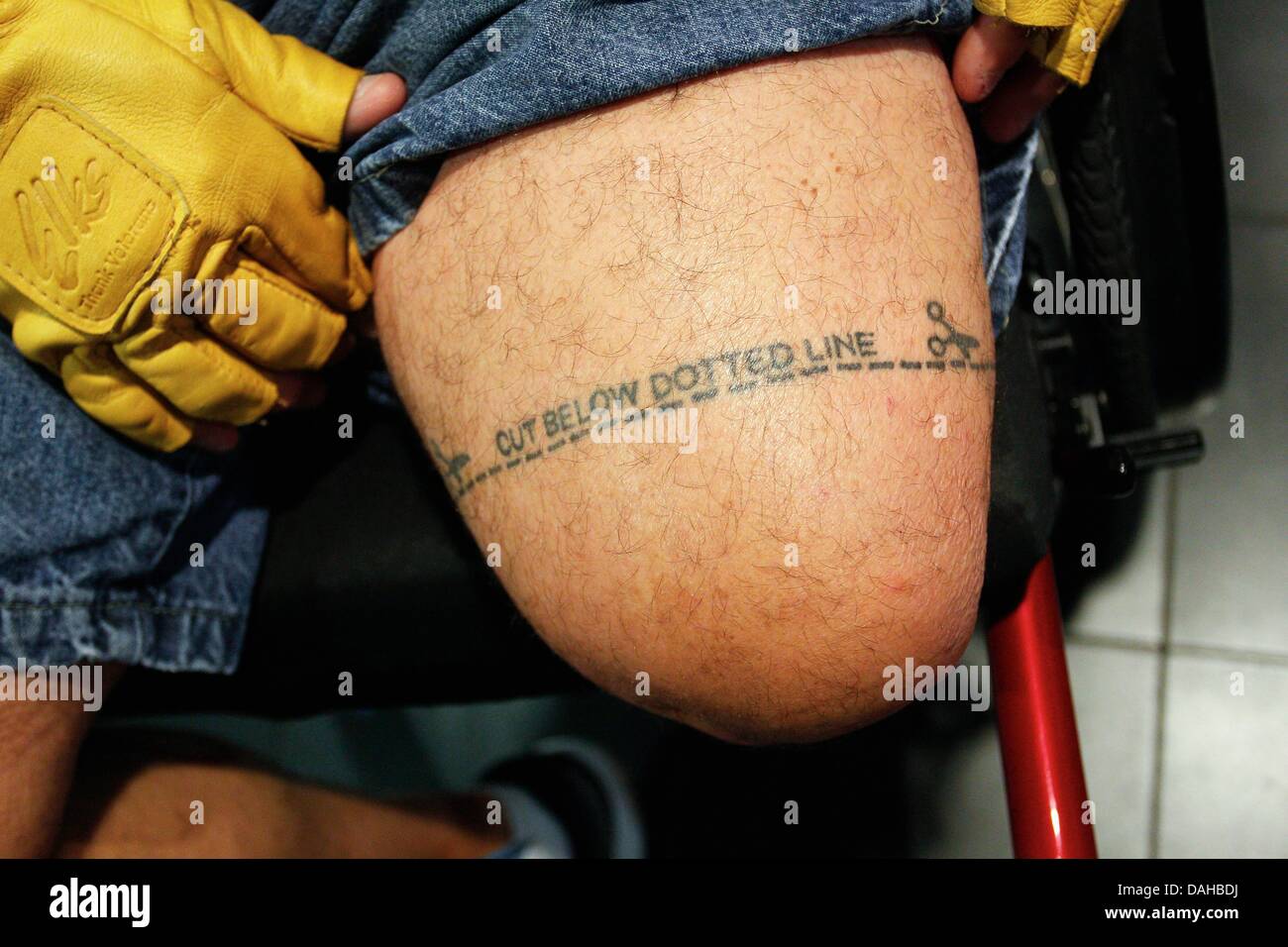 Tampa, Florida, USA. 13th July, 2013. DANIEL WALLACE | Times.Dave Nelson, 50, a Navy veteran from Nebraska, shows his sense of humor with a tattoo above his amputated knee before opening ceremonies for the 33rd National Veterans Wheelchair Games at the Tampa Bay Times Forum on Saturday, July 13, 2013. Nelson lost his lower leg after two amputations due to a staph infection. This is his sixth games, this year he is competing in the hand cycle race, bowling, shot put, discus and nine ball events. Credit:  Daniel Wallace/Tampa Bay Times/ZUMAPRESS.com/Alamy Live News Stock Photo