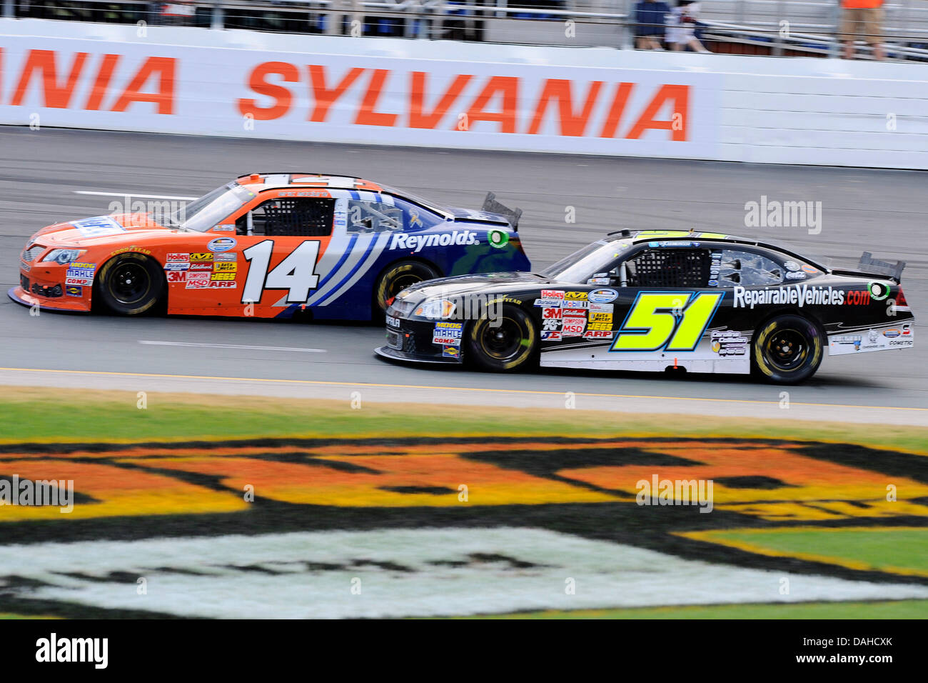 Loudon, NH, USA. 13th July, 2013. July 13, 2013 - Loudon, New Hampshire U.S. - Nationwide Series driver Eric McClure (14) and driver Jeremy Clements (51) battle into turn #2 while racing in the NASCAR Nationwide Series CNBC Prime's ''The Profit'' 200 race being held at the New Hampshire Motor Speedway in Loudon, New Hampshire. Eric Canha/CSM/Alamy Live News Stock Photo