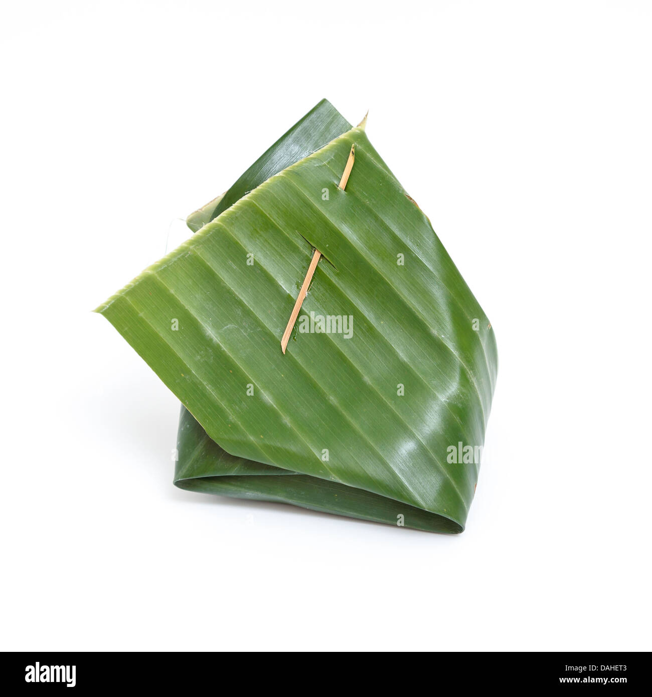 Thai dessert wrapped in banana leaf isolated on white background Stock