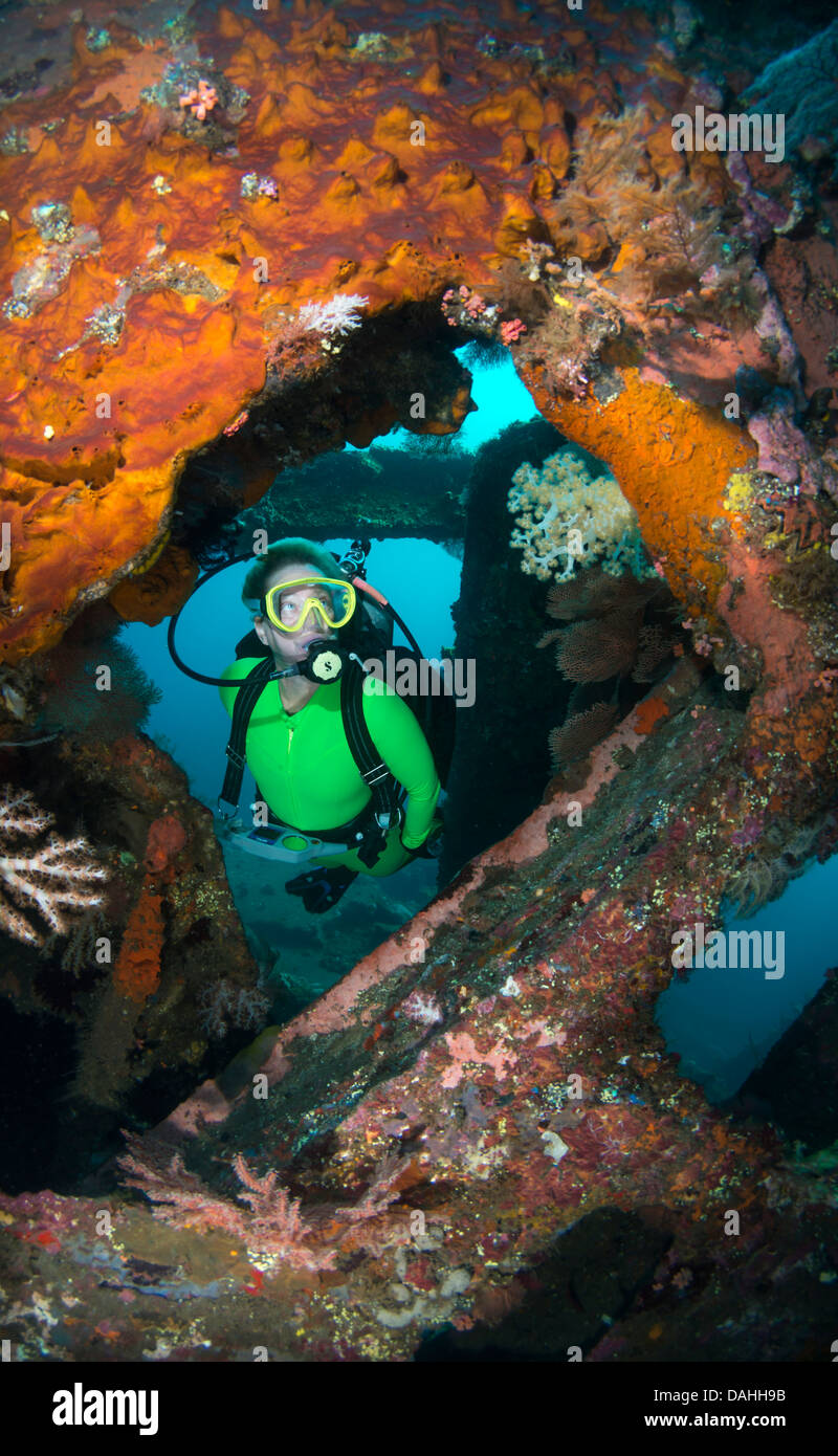 Female scuba diver exploring interior of wreck, Tulamben, Bali, Indonesia Stock Photo