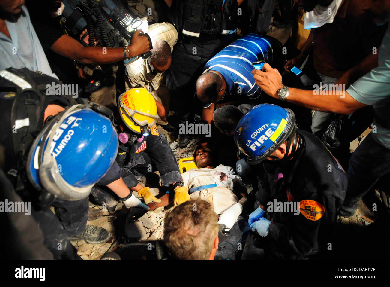 Members of the Los Angeles County Fire Department Search and Rescue Team rescue a Haitian woman from a collapsed building in the aftermath of a 7.0 magnitude earthquake that killed 220,000 people January 17, 2010 in Port-au-Prince, Haiti. The woman survived 5 days without food or water in the debris. Stock Photo
