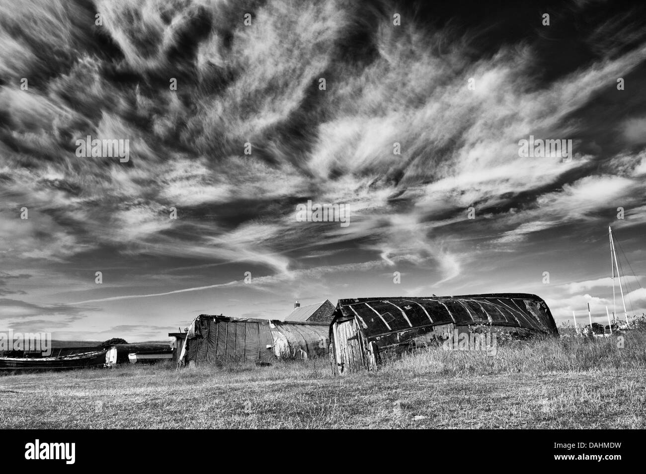 Herring boat sheds in the harbour at Lindisfarne, Northumberland, England. Monochrome Stock Photo