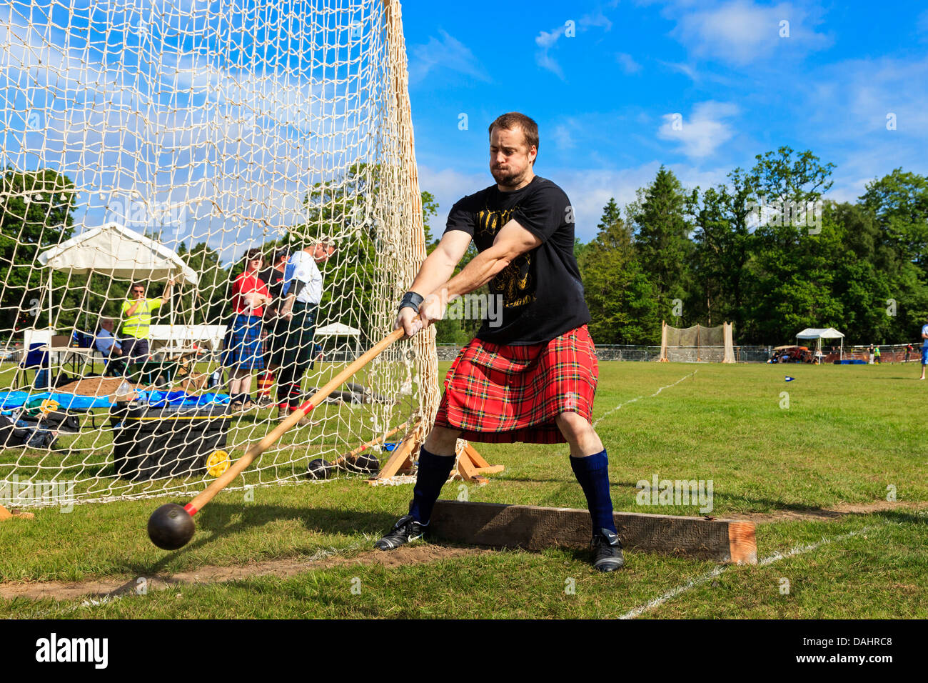 Competitor at Scottish highland games throwing the 22 pound hammer, a