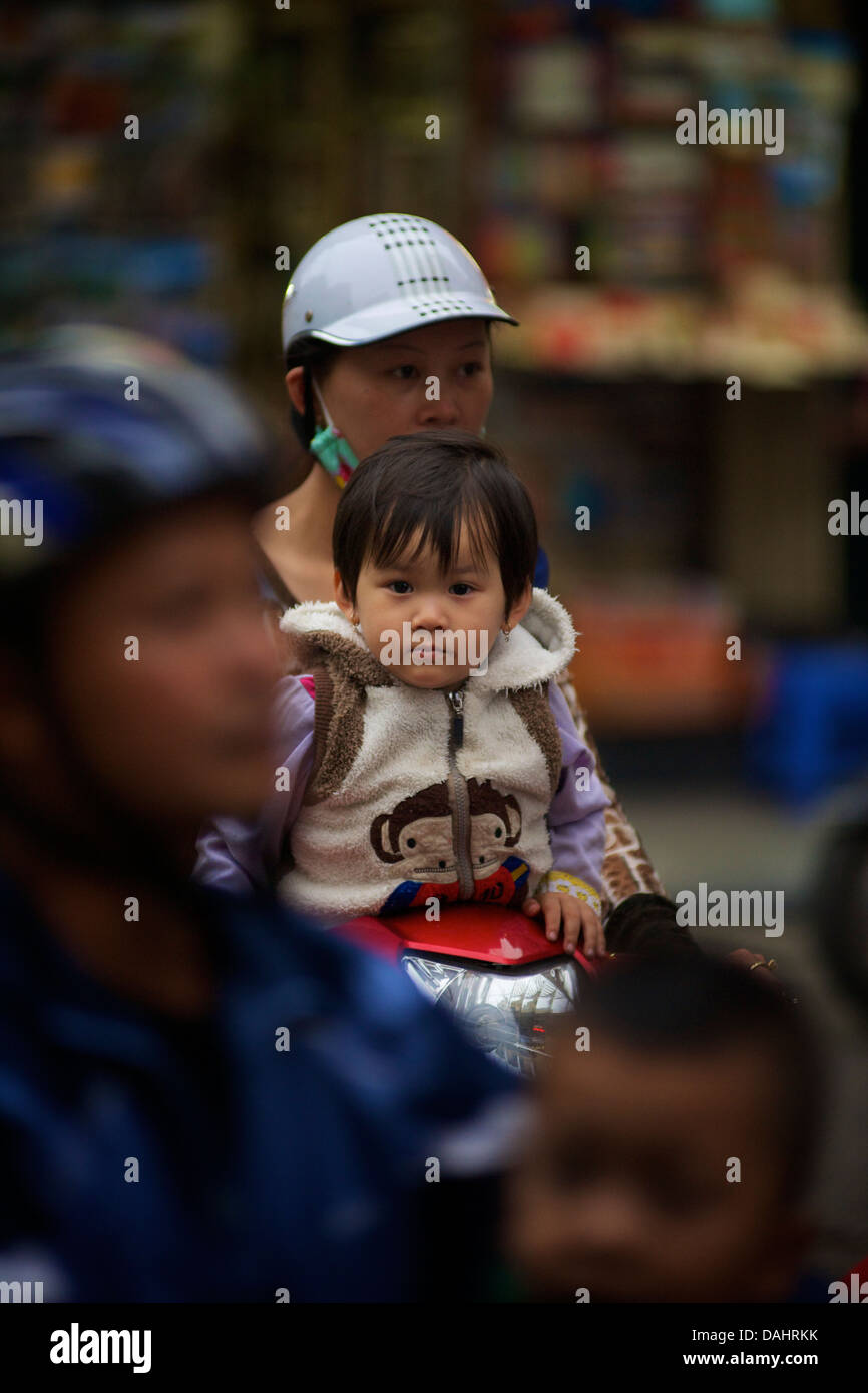Vietnamese woman on motorcycle with daughter, Old Quarter, Hanoi ...