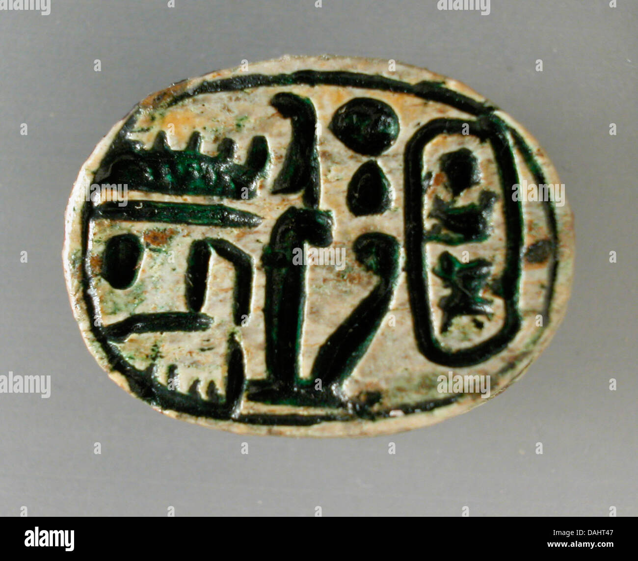 This scarab features the royal names of Seti I and the deified King Thutmose III, important figures in Egyptian history. Scarabs were commonly used as amulets in ancient Egypt, symbolizing protection and regeneration. Stock Photo