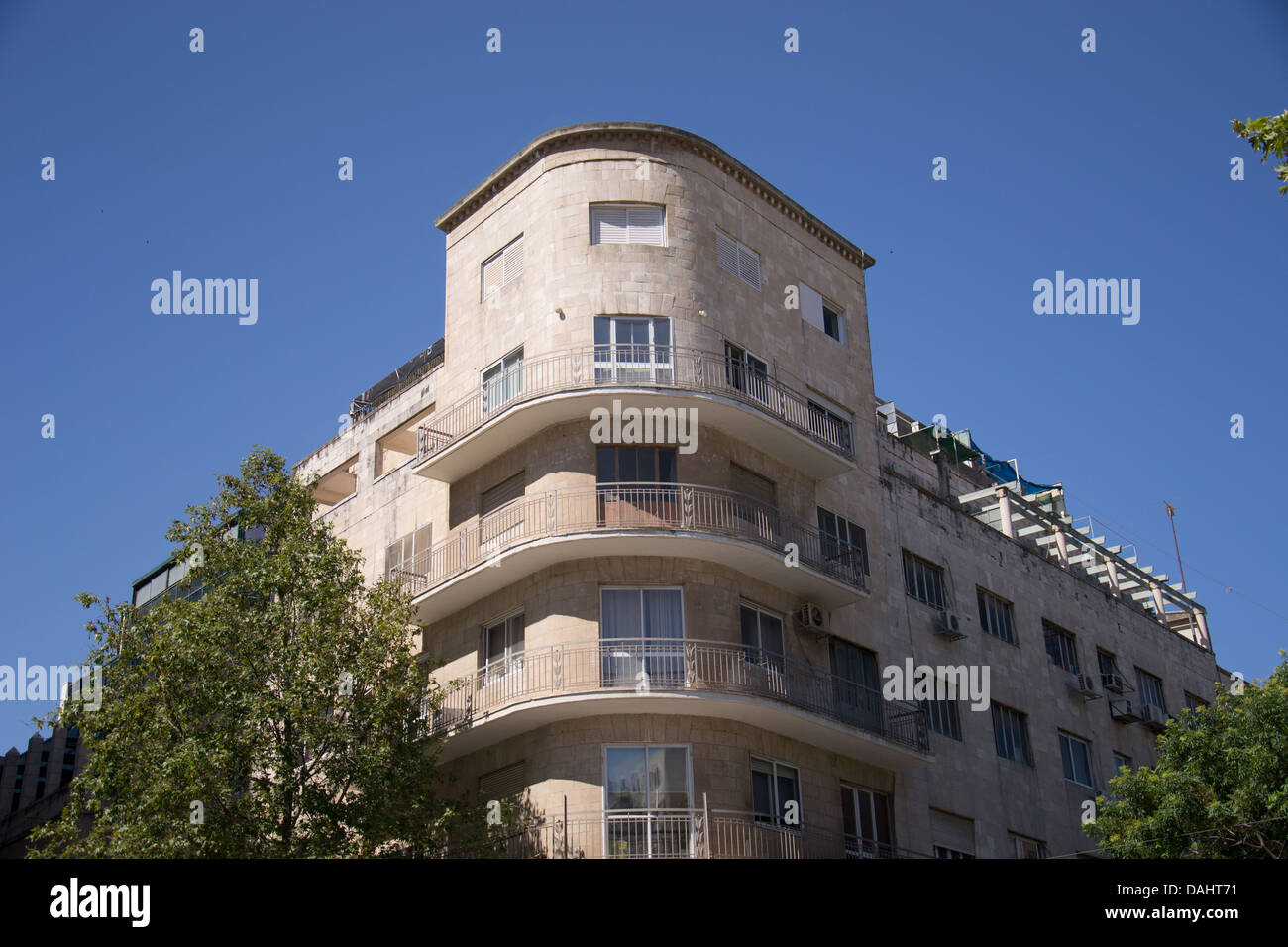 Old brick building against a clear blue sky with trees Stock Photo